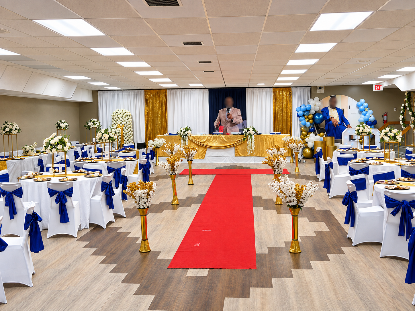 Royal blue and gold reception with a red carpet aisle, sashed chair covers, and a styled head table