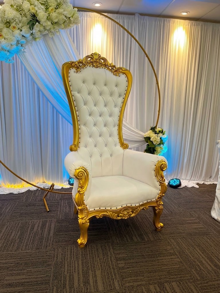 White and gold tufted throne chair with a floral crown and a gold ring backdrop
